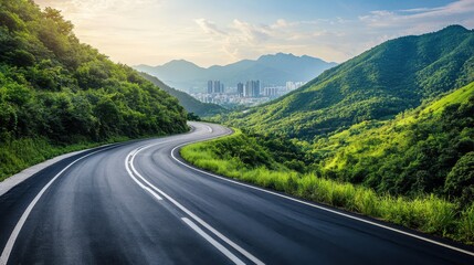 Naklejka premium A long asphalt highway winding through lush green mountains, on blurred background
