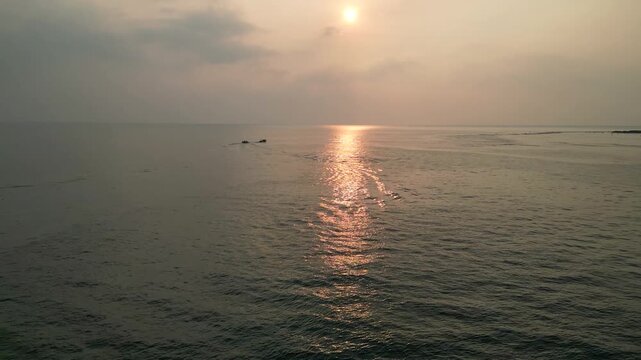 Donut bot watersport ride towed by speed boat on calm sea at sunset, fun holiday adventure in summer vibes.