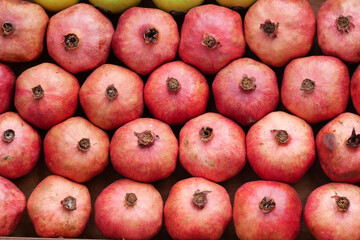 Fresh pomegranates arranged neatly in a market display
