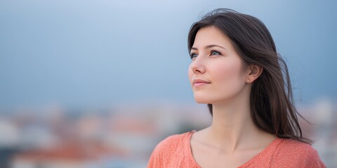 Contemplative Young Woman Gazing into the Distance Against a Soft Urban Background