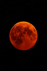 Vibrant red full moon glowing in the dark night sky © Kabirdesigner77