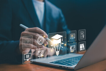 Business professional using laptop and a stylus with digital icons of a graduation cap, a book, and training, symbolizing online education, e-learning, corporate training, and knowledge development.