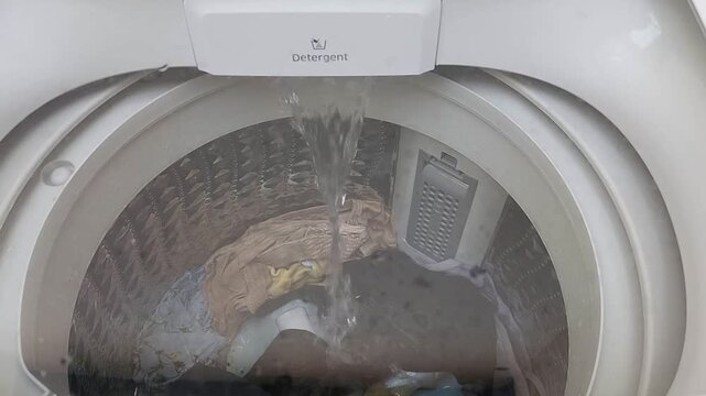 top view of a top-loading washing machine in water filling or soaking mode