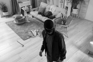 Male thief stealing valuables in room, view through security camera