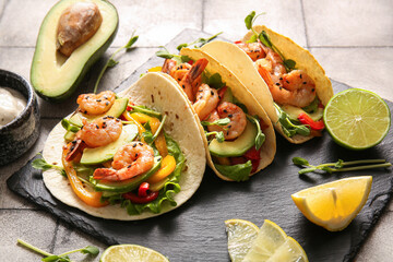 Tasty tacos and ingredients on grey tile background