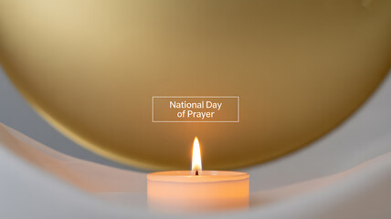 A lit candle in a white holder with a golden background, commemorating the National Day of Prayer.