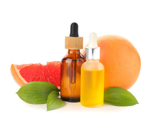 Bottles of grapefruit cosmetic oil and fruits on white background