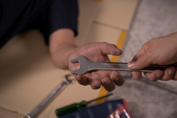 Two handsome mechanics are working together on a car repair.