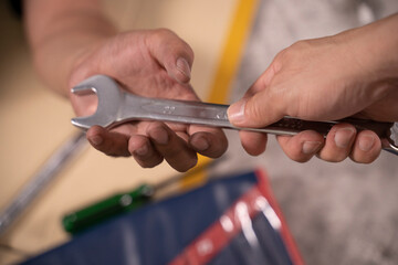 Two handsome mechanics are working together on a car repair.
