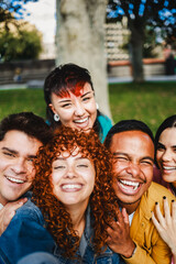 Group of friends taking selfie picture smiling at camera. Young people have fun celebrating outdoors. Vertical photo