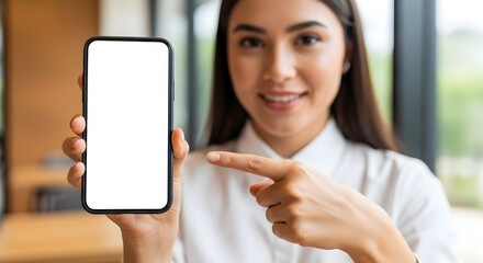Smiling Young Woman Holding Blank White Screen Smartphone and Pointing, Ideal for App Mockup, Digital Marketing, Ad Space, and Product Presentation