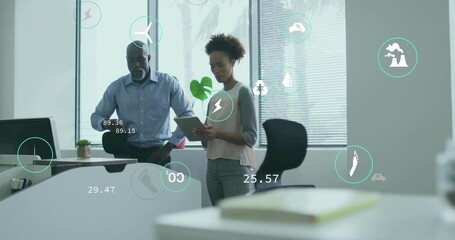Male colleague tapping cycling icons, female coworker swiping tablet evaluating sustainability data - Powered by Adobe