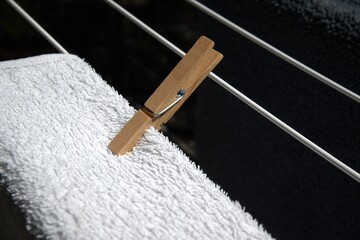 Household towel drying on a clothesline outdoors, close-up view.