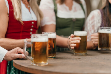 Close up of beer mugs clinking in a lively beer garden scene symbol of fun friendship leisure and traditional German celebration atmosphere