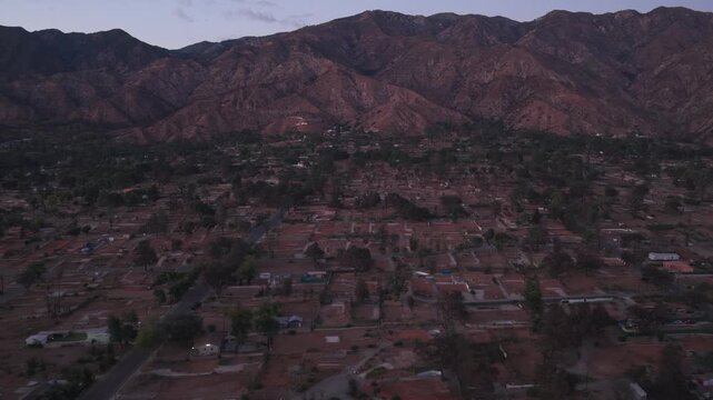 Aerial low dolly shot of burned lots in Altadena at sunset in Southern California. 4K