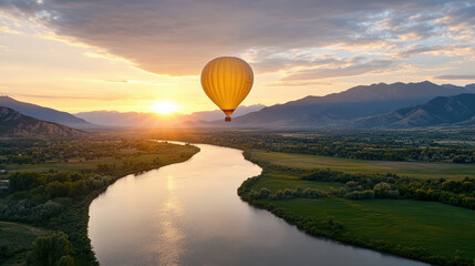 Fototapeta premium Hot air balloon floats gracefully over serene river sunrise, surrounded by lush landscapes