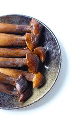 Termite mushrooms with long stems, white tips, and dark brown caps.