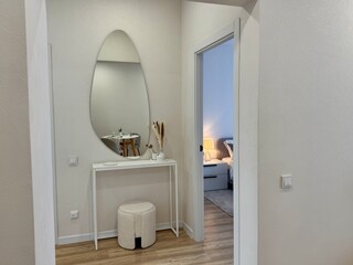 Modern stylish interior in a new apartment, dressing table with a hanging mirror in white tones