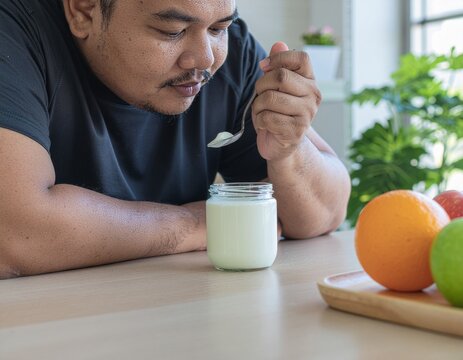 A fat man eating yogurt