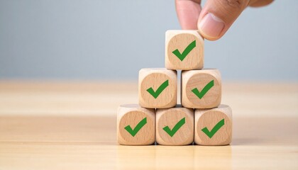 Hand placing top block on pyramid of check-marked blocks—achievement icon and structured form evoke progress, goal completion, and success in minimalist productivity symbolism composition.