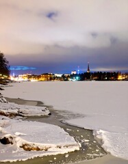 A winter night cityscape reflected on frozen water