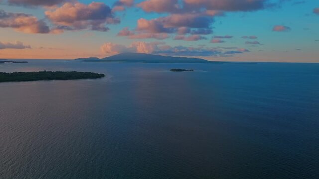 Wewak Madang Papua New Guinea aerial drone PNG tropical island vibrant sunset golden hour dusk Pacific Ocean Dogreto bay Cape Wom Yuo Mushi island remote pristine coastline harbor view clouds forward