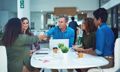 Obraz premium Handshake, meeting and business people in office with deal, negotiation or partnership. Discussion, laptop and manager with creative editor for shaking hands on publishing agreement in workplace.