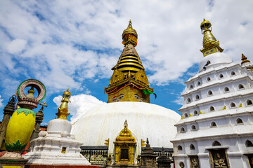 A stunning view of the golden Swayambhunath stupa in Nepal, adorned with intricate Buddhist symbols and surrounded by peaceful clouds. This UNESCO World Heritage site is a symbol of Nepalese spiritual