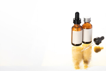 Minimalist skincare setup featuring amber dropper bottles with golden shadow symbolizing self-care, cosmetic luxury, and purity in beauty.