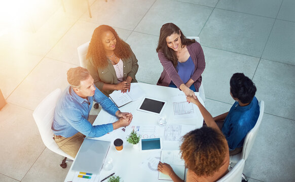 Profit, sales or people in meeting with handshake, business deal or partnership in company development. Above, revenue growth or data analysis team in office with tech, collaboration or shaking hands