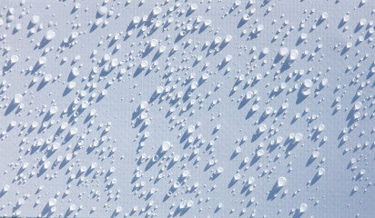 A close up of a wet surface with many small droplets of water