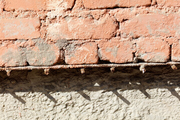 A brick wall with a metal bar on the side