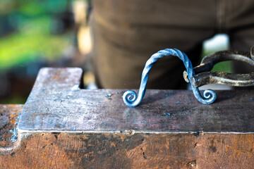 Forged ironwork with curled ends on anvil
