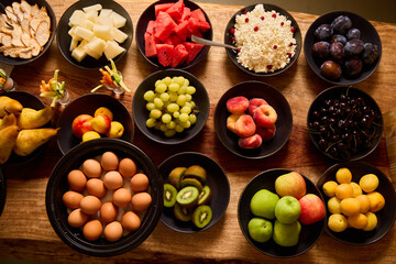 Fruit and egg display on a wooden table during a vibrant gathering