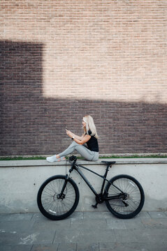Attractive woman using smartphone after cycling outdoors