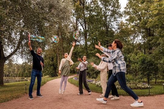 People have fun with soap bubbles in nature.