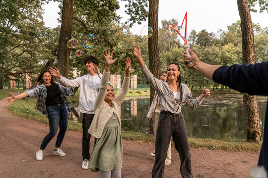 People have fun with soap bubbles in nature.