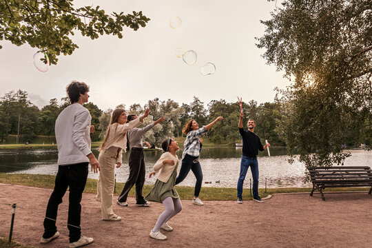 People have fun with soap bubbles in nature.
