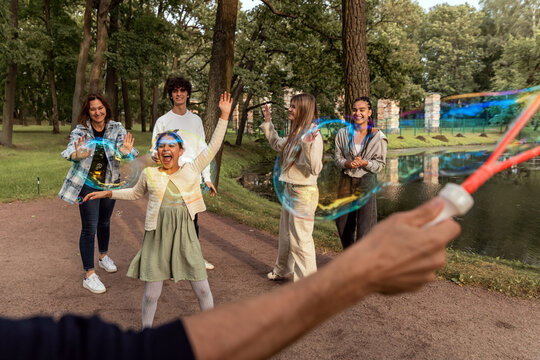 People have fun with soap bubbles in nature.