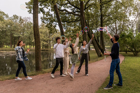 People have fun with soap bubbles in nature.
