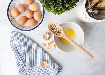 Overhead view of cracked eggs in bowl on bright kitchen countertop