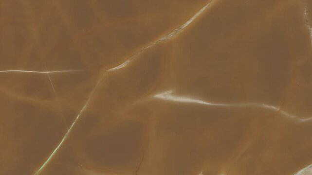 Detailed view of a brown marble slab with white veining and natural stone texture patterns across surface
