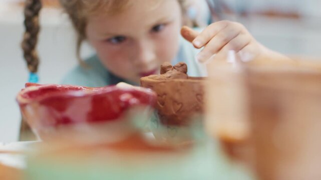 Girl learns pottery and shapes the clay in the pottery workshop during masterclass