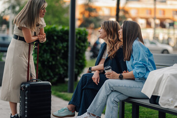Businesswomen talking on a bench while waiting for transportation