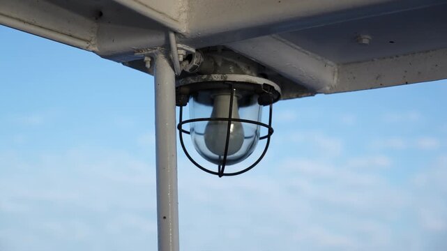 Industrial outdoor bulkhead lamp on a ship's deck. Clip