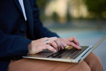 Businesswoman Typing On Laptop Outdoors In Formal Attire, Focused, Ring Glint, Sunlight, Professional Work