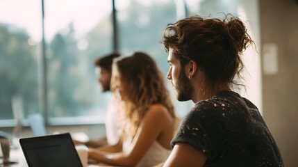 Diverse team of professionals collaborating and working on laptops in a modern bright coworking office space focused on productivity and innovation