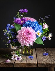 Vibrant flower arrangement in a glass vase on a rustic wooden table