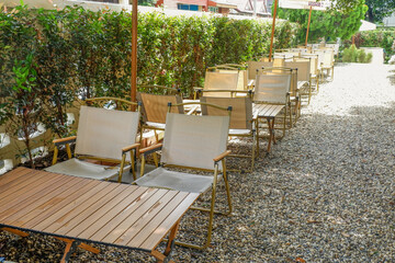 Colorful folding camping chair,wooden and chair set in garden on a sunny day,outdoor seating for restaurant or cafe.