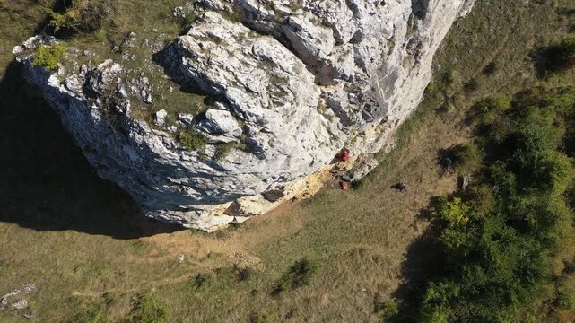  Flying near a mountain rescuer rappelling on a rocky wall with a drone